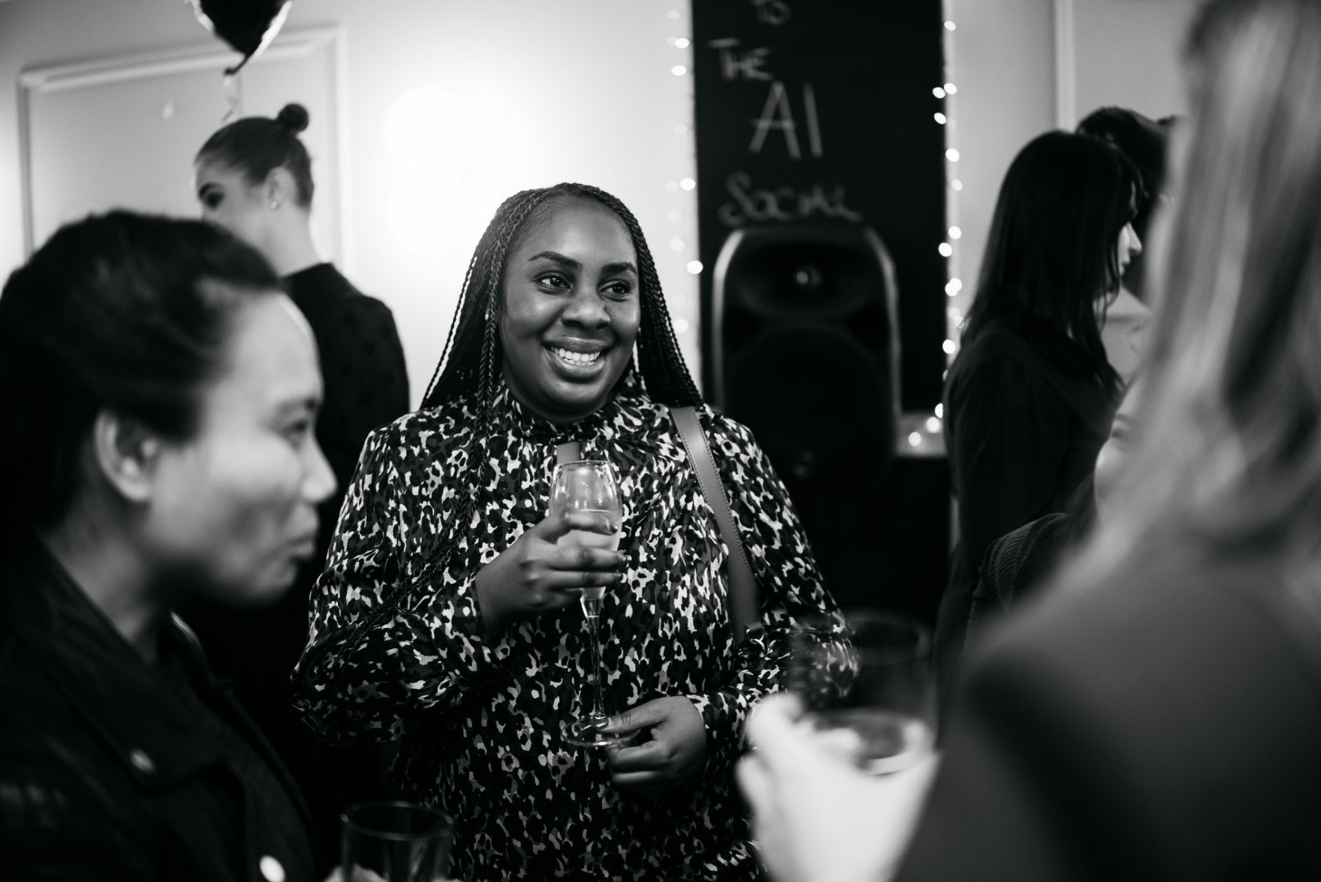 A guest smiling with a glass of champagne at the launch